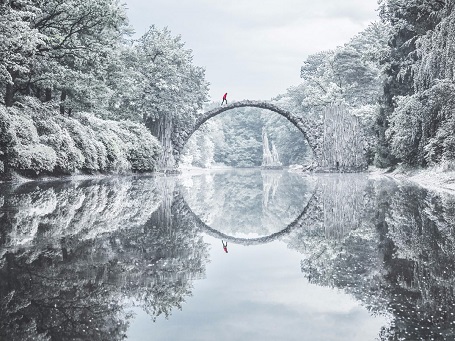   Hình ảnh này được chụp trên cây cầu Rakotzbrücke ở khu rừng phía đông nước Đức. Để tìm ra cây cầu và chụp được khoảnh khắc đẹp tới huyền ảo này, tác giả đã phải đi bộ ròng rã trong cái lạnh thấu xương băng qua rừng và ngôi làng biệt lập với trải nghiệm không thể nào quên.  