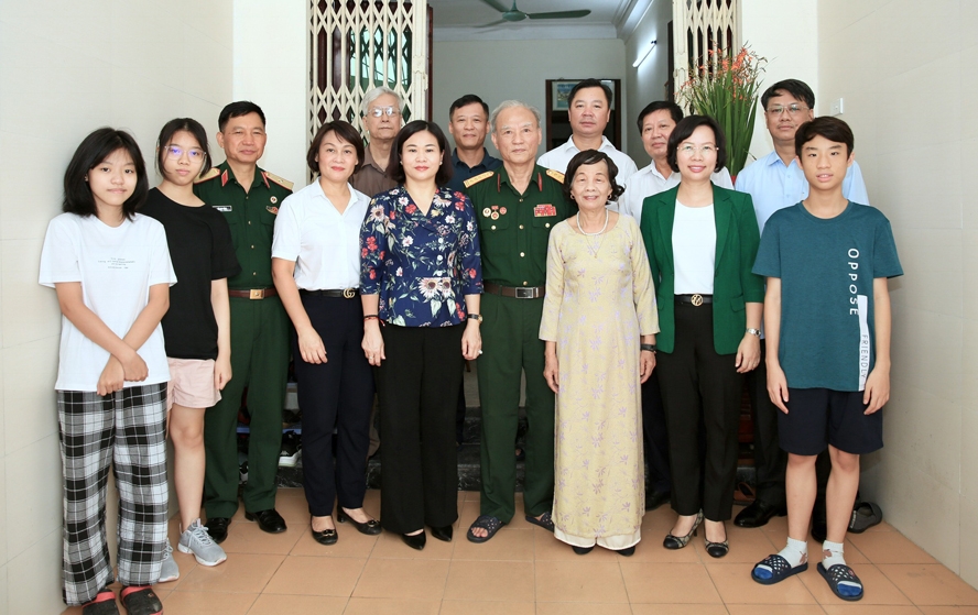  lãnh đạo thành phố chụp ảnh lưu niệm với gia đình thương binh Nguyễn Thanh Bang. (Ảnh: Nguyễn Thái)