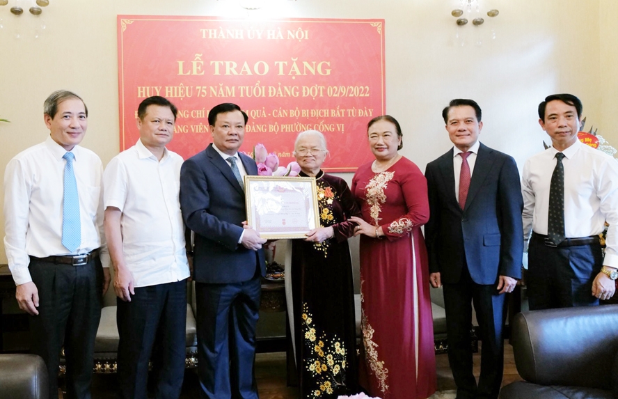 Bí thư Thành ủy Đinh Tiến Dũng trao Huy hiệu 75 năm tuổi Đảng cho đồng chí Lê Thị Kim Quả.
