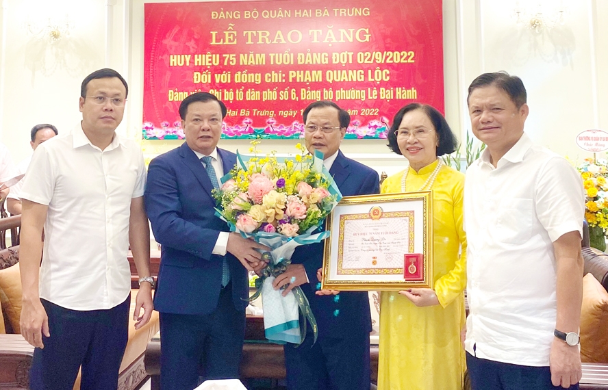 Bí thư Thành ủy Đinh Tiến Dũng trao Huy hiệu 75 năm tuổi Đảng cho đại diện gia đình đồng chí Phạm Quang Lộc.
