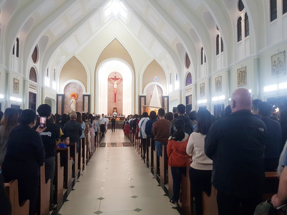 Nhiều giáo dân và người nước ngoài tham gia buổi Lễ cầu nguyện trước giờ Giáng sinh tại Nhà thờ Giáo xứ Ba làng. (Ảnh: Hương Thảo)