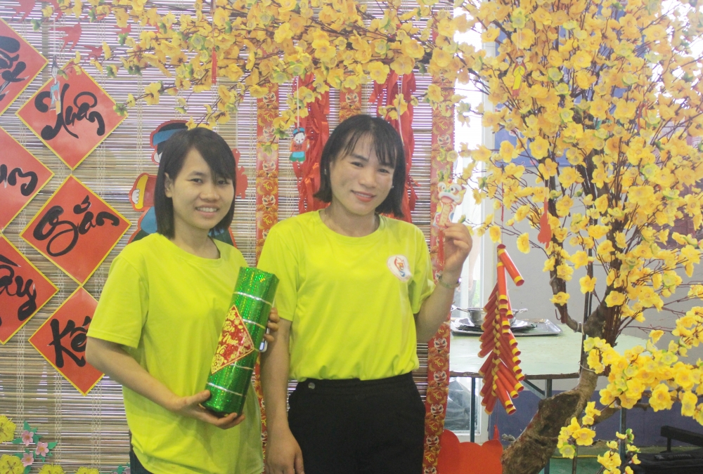 Đội thi LĐLĐ huyện Diên Khánh chụp hình trước tác phẩm trang trí hoa mai của đơn vị mình. (Ảnh: Hương Thảo)