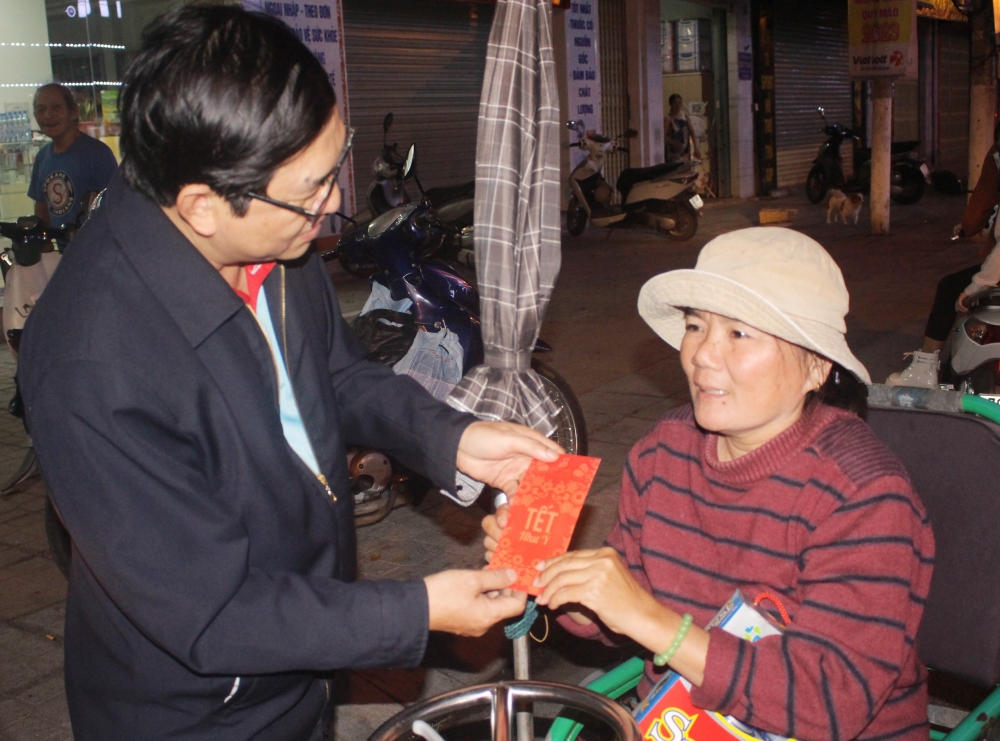 Ông Trần Hồng Minh trao phong bao lì xì với mệnh giá 100.000đ cho các hoàn cảnh khó khăn. (Ảnh: Hương Thảo)