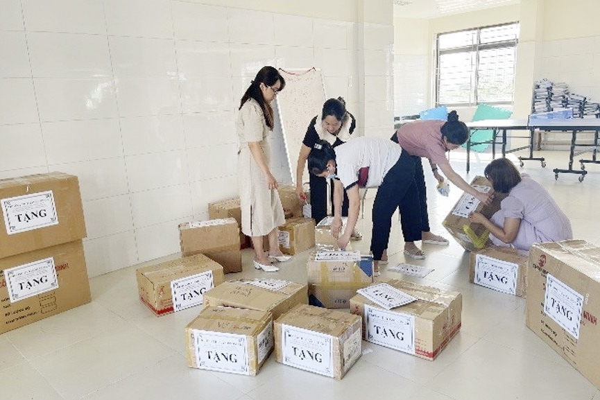Giáo viên quận Ba Đình soạn sách vở, đóng thùng cẩn thận gửi tặng học trò nghèo vùng cao. (Ảnh: ĐVCC)
