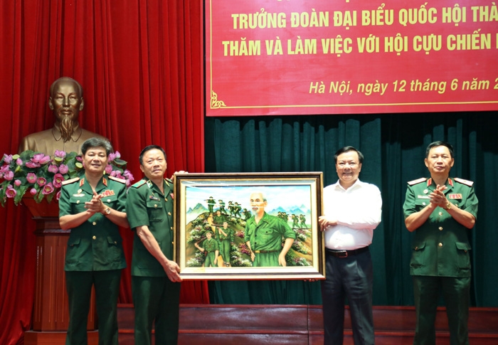 Bí thư Thành ủy Đinh Tiến Dũng trao tặng Hội Cựu chiến binh Thành phố bức tranh “Bác đang cùng chúng cháu hành quân”. 