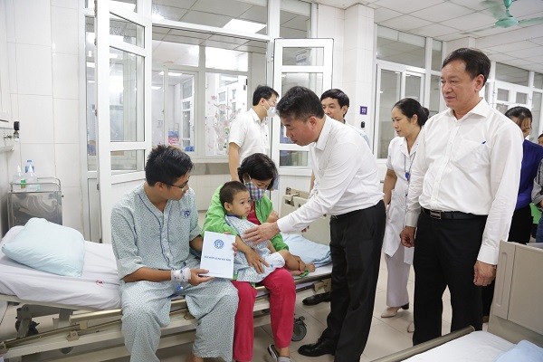 Tổng Giám đốc BHXH Việt Nam Nguyễn Thế Mạnh thăm hỏi người bị thương trong vụ hỏa hoạn.