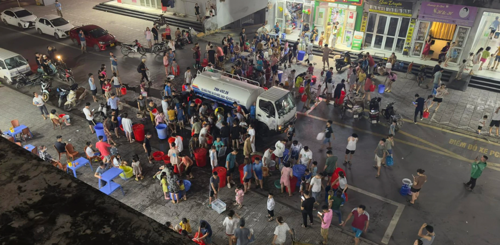 Người dân khu đô thị Thanh Hà mang xô chậu lấy nước từ xe téc tối 17/10.