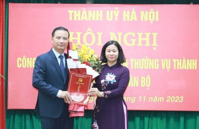 Phó Bí thư Thường trực Thành ủy Nguyễn Thị Tuyến trao quyết định và tặng hoa chúc mừng tân Bí thư Quận ủy Hoàng Mai Nguyễn Xuân Linh