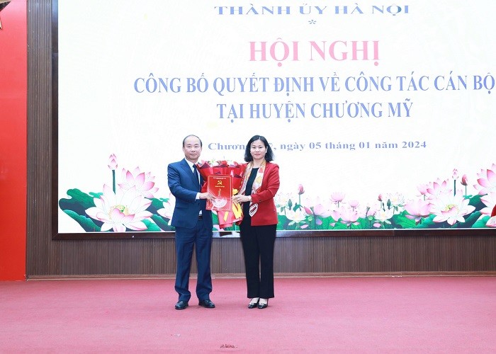 Phó Bí thư Thường trực Thành ủy Nguyễn Thị Tuyến trao quyết định, tặng hoa chúc mừng đồng chí Nguyễn Đình Hoa