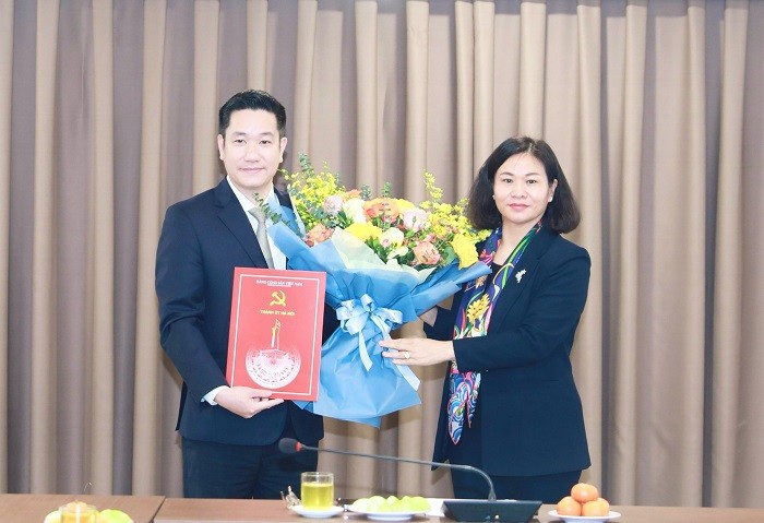 Phó Bí thư Thường trực Thành ủy Nguyễn Thị Tuyến trao quyết định, tặng hoa chúc mừng đồng chí Nguyễn Huy Cường