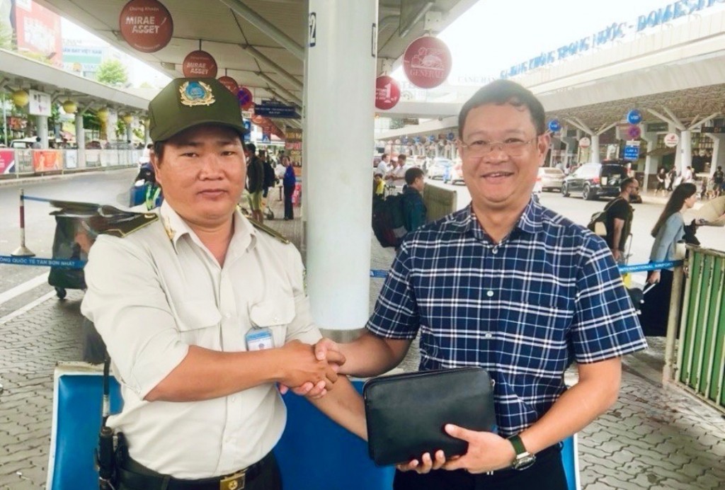 Nhân viên an ninh của Cảng HKQT Tân Sơn Nhất trả lại đồ cho khách. (Ảnh: T.Tú)