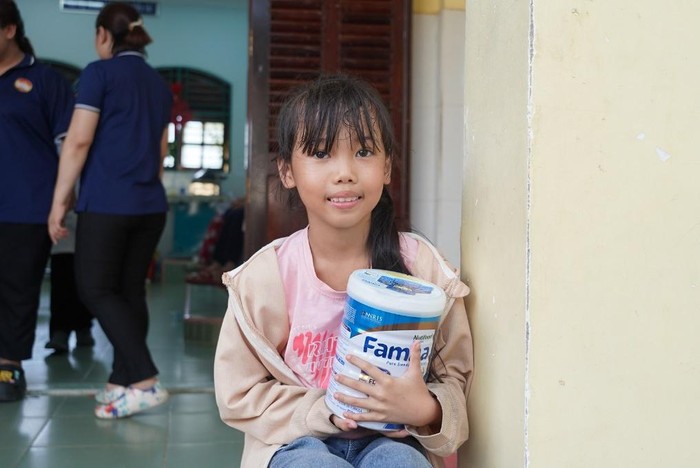 Em Đào Thu Hạnh (học sinh lớp 3 Trường Tiểu học Long Thạnh) hạnh phúc ôm lon sữa trong tay.