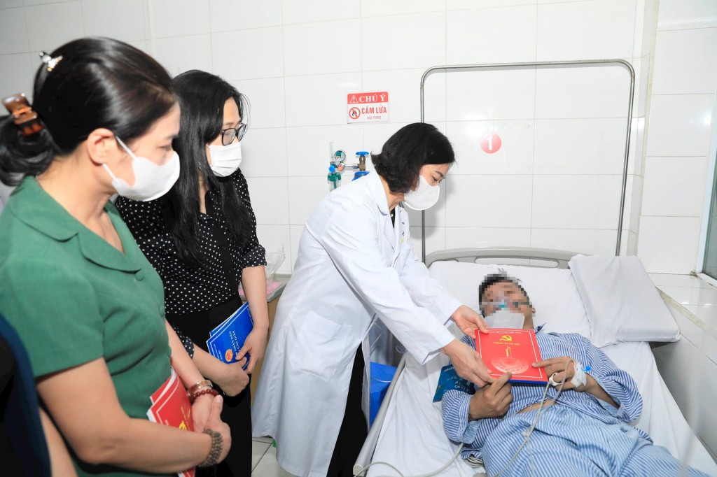 Phó Bí thư Thường trực Thành ủy Hà Nội Nguyễn Thị Tuyến trao hỗ trợ cho nam nạn nhân trong vụ cháy nhà trọ tại phố Trung Kính đang điều trị tại Bệnh viện Giao thông vận tải
