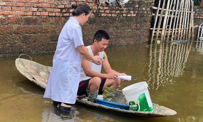 Cán bộ Trung tâm y tế huyện cấp phát thuốc cho người dân vùng bị ngập lụt.