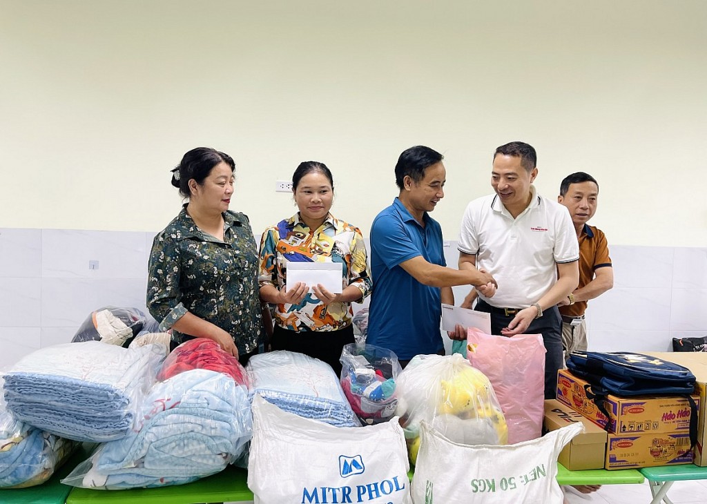 Cô giáo Đinh Thị Thuyết, hiệu trưởng trường Mầm non An Phú B và thầy giáo Hồ Phong Vũ, hiệu trưởng Trường tiểu học An Phú nhận quà hỗ trợ từ Báo Lao động Thủ đô và các nhà hảo tâm