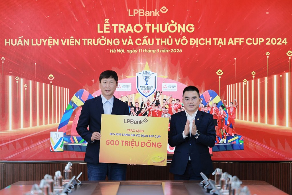 Ông Hồ Nam Tiến, Phó Chủ tịch thường trực HĐQT LPBank (phải) trao tặng 500 triệu đồng cho ông Kim Sang Kik, HLV trưởng Đội tuyển Quốc gia Việt Nam