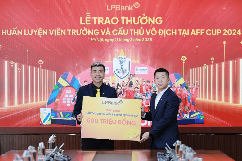 Ông Vũ Quốc Khánh, Tổng Giám đốc LPBank (phải) trao tặng 500 triệu đồng cho cầu thủ  Đinh Thanh Bình