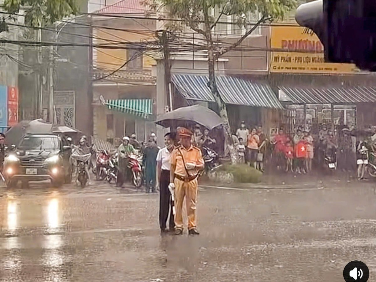 Người phụ nữ che ô cho CSGT dầm mưa, khoảnh khắc lay động triệu trái tim