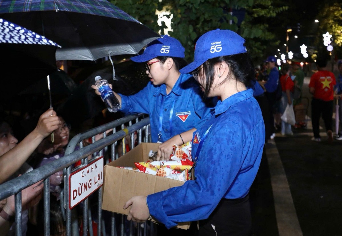 Các bạn bạn trẻ áo xanh trao đồ ăn nhẹ, nước uống phục vụ nhân dân trong những nụ cười lễ phép và thân thiện.