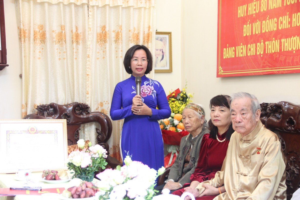 Chủ tịch Ủy ban MTTQ Việt Nam thành phố Hà Nội Bùi Huyền Mai trao huy hiệu 80 năm tuổi Đảng đến cụ Hoàng Quang Trịnh