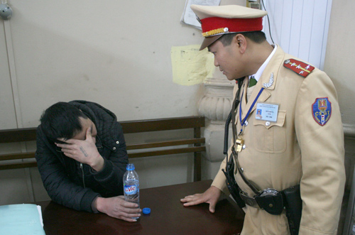 Đại úy Trần Phong đang tra hỏi tên cướp tại trụ sở công an. Ảnh: Bá Đô
