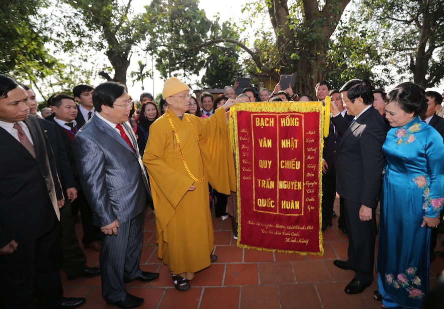 Chủ tịch nước cùng bà con thưởng thức câu đối tại lễ dâng hương và thả cá chép tại chùa Trấn Quốc