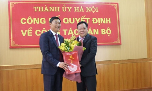 Phó Bí thư Thành ủy Hà Nội Nguyễn Văn Phong trao quyết định và tặng hoa chúc mừng đồng chí Đỗ Anh Tuấn.