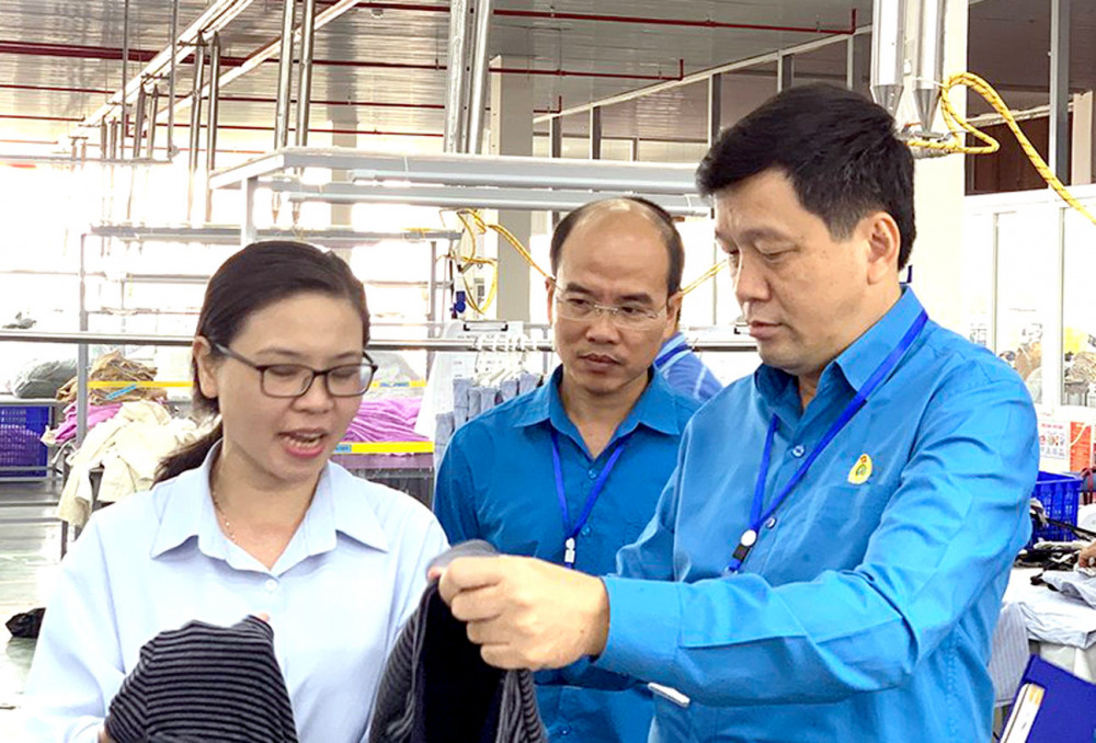 Chủ tịch LĐLĐ tỉnh Nghệ An Kha Văn Tám (bên phải) thăm hỏi, động viên CNLĐ tại doanh nghiệp may huyện Tân Kỳ.