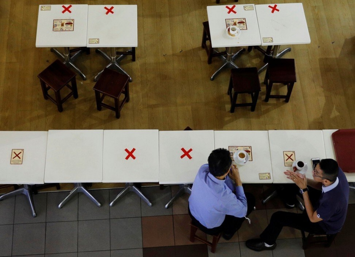 Những chiếc bàn được đánh dấu để thực hiện giãn cách tại một quán café ở Singapore. Ảnh: Reuters