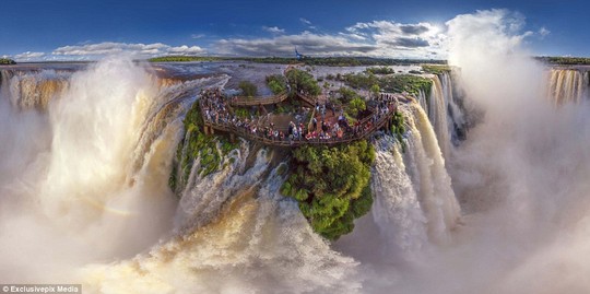 Iguazu Falls on the border of Brazil and Argentina:  People gather on a viewing platoform to marvel at the staggering power of the falls
