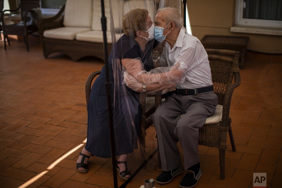 Agustina Canamero, 81 tuổi và Pascual Perez, 84 tuổi, trao nhau nụ hôn qua tấm chắn nhựa tại một viện dưỡng lão ở Barcelona (Tây Ban Nha) để phòng dịch Covid-19. Ảnh: AP
